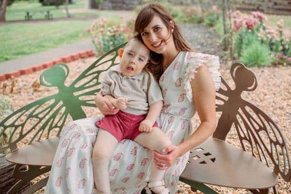 Young woman with a child sitting on a butterfly-shaped park bench.